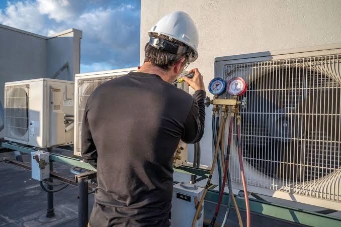 Technician servicing condenser units